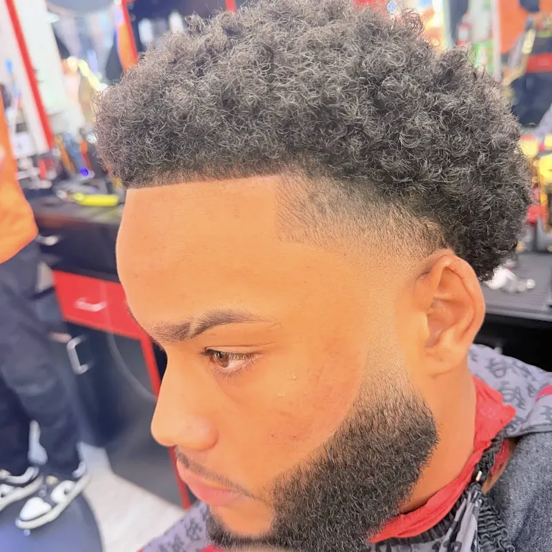 Rizos con esponja, taper fade y barba perfilada